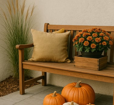 Wood bench with mustard pillow and crate of orange mums beside a cluster