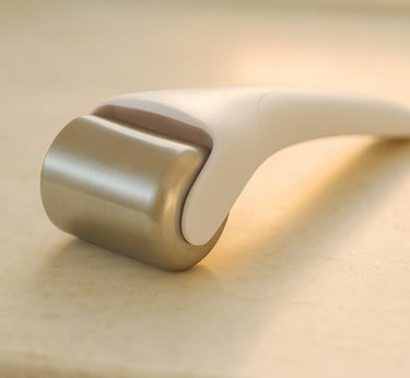 Stainless-steel ice roller resting on marble in early-morning soft light.