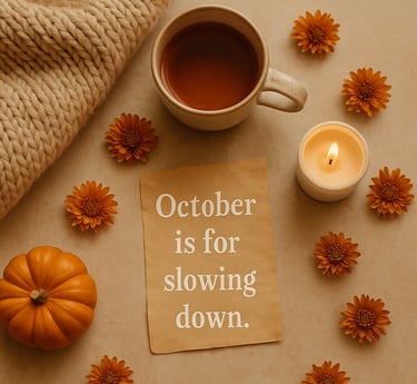 Cozy fall flat-lay with a cup of tea, candle, small pumpkin, and orange flowers