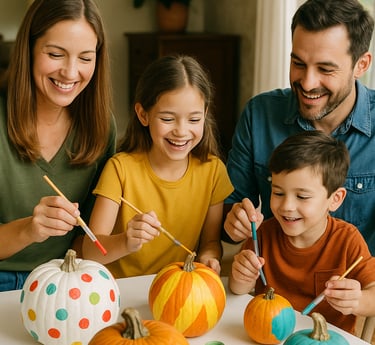 a family of four painting pumpkins at a crafts table