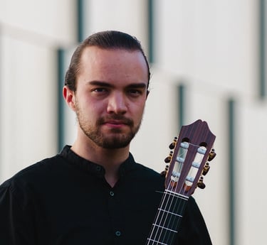 Classical guitarist Filip Babic holding guitar outside summer photo