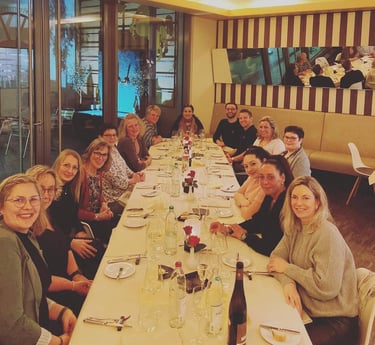 a group of people sitting at a long table