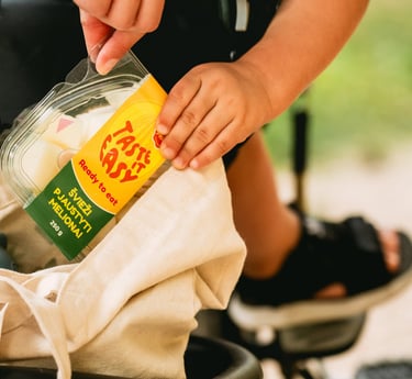 iš medžiaginio maišo mama ir vaikas ištraukia pjaustyto meliono indelį