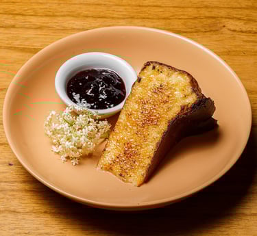 a plate of a slice of cheesecake and a bowl of jam