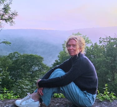 Tanja Holvoet in een rustige natuuromgeving bij zonsondergang.