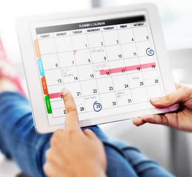 a person holding a tablet with a calendar on it