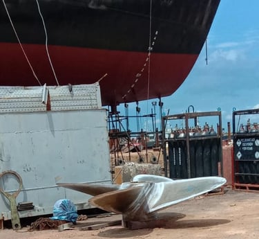 a boat sitting on the ground next to a large boat