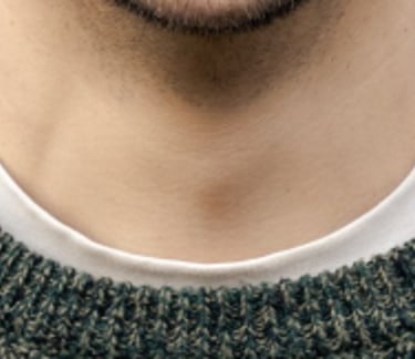 a man smiling in front of a brick wall background