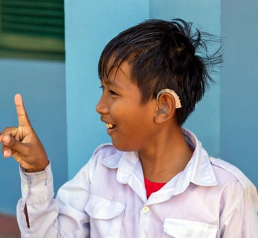 a young boy with hearing aid on his head