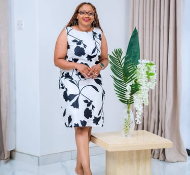 a woman in a white dress standing in front of a table with a vase with