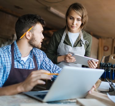 Dos comerciantes viendo su laptop y tablet