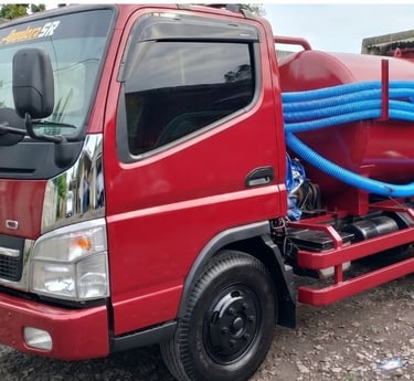 Armada truk Mitsubishi Fuso jasa sedot WC Pekanbaru dengan peralatan selang biru lengkap