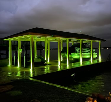 a boat dock that has lights shining on the columns with color changing lamps