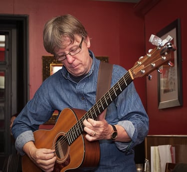 Man playing a guitar in a room
