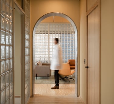 Fertility doctor walking through warm, modern clinic hallway – book a free consultation.