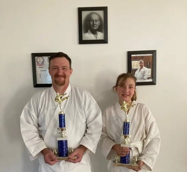 Father and daughter family karate students pose with awards