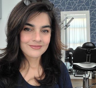 Shazia Ittiq, licensed permanent makeup artist in Oklahoma City, smiling at her desk