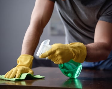 Cleaning a table with spray bottle and rag