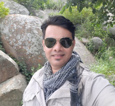 a man in sunglasses and a scarf around his neck, raheel ahmed