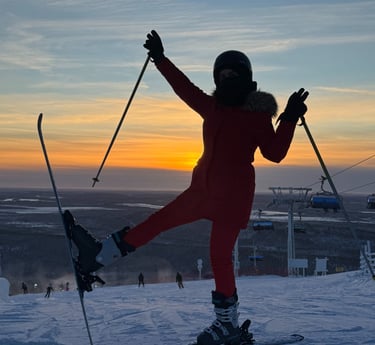 a person standing on a ski slope with their arms up