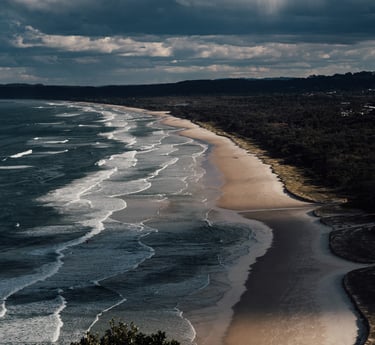 a beach with a view of a beach and a person on a surfboard
