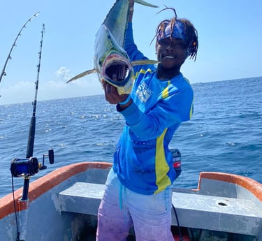 a man holding a fish on a boat