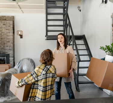 a military family moving boxes in a house during their PCS Move