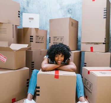 a happy woman with packed boxes for her pcs move