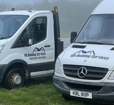 a couple of KB Building Services vans parked in a field