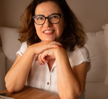 a woman sitting at a table with a laptop