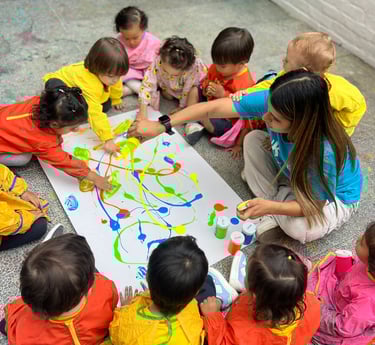 Niños con pinturas brillantes jugando sentados en el piso