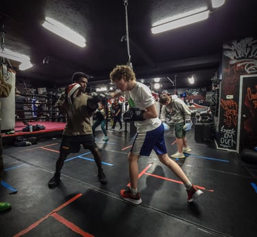 two men training with boxing gloves and pads
