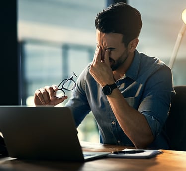 Ein Mann im Büro der zu viel Stress spürt