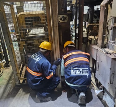 two men in safety gear working on a forklift