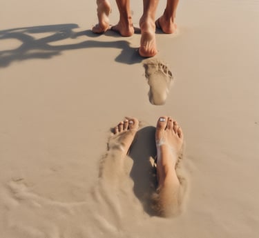 Close-up of creamy shea butter and amber carrier oil bottles surrounded by natural leaves.