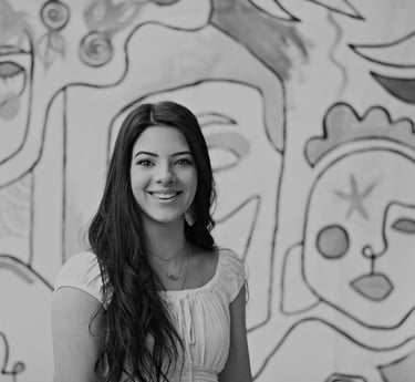 a woman in a white dress standing in front of a wall with a mural of