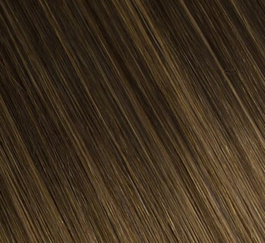 Gros plan de la texture de rallonges de cheveux blond foncé avec des reflets miel et une finition li