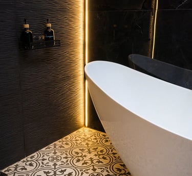 Ducha de diseño moderno con textura negra, bañera blanca independiente e iluminación LED cálida.