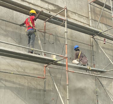 Trabajo en fachada con andamios en proceso de repello.