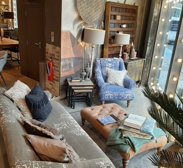 a living room with a sofa a armchair a wall mural and accessories