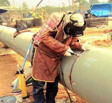 a man in a welding helmet welding a pipe