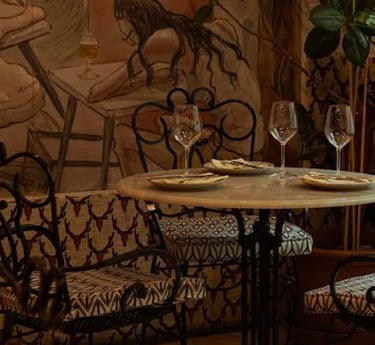 Interior del restaurante con mesa preparada, platos y copas de vino en un ambiente elegante y acoged