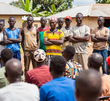 Farmers harvesting ripe coffee cherries under the warm Ugandan sun in the Mubende coffee belt.