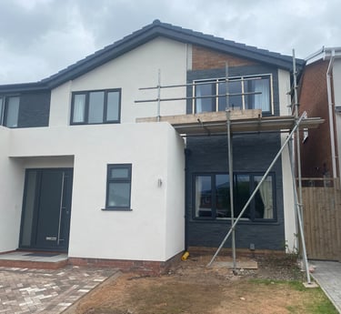 A partially rendered house with scaffolding against it.
