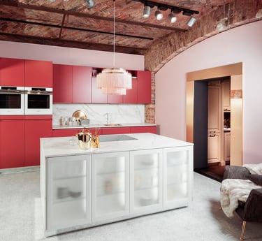 Una cocina con una isla roja y una encimera blanca.