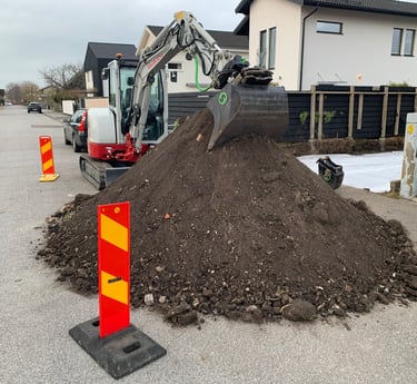 a pile of dirt with a construction worker in the background