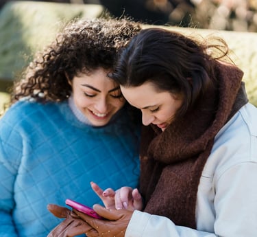Mujeres usando el telefono mientras disfrutan su viaje