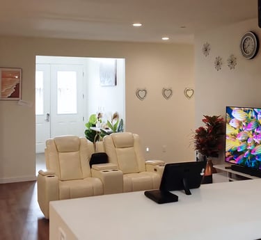 Cozy living area at Holistic Haven (AFH) with comfortable sofas, large TV, and warm, home-like decor for residents.