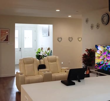 Cozy living area at Holistic Haven (AFH) with comfortable sofas, large TV, and warm, home-like decor for residents.