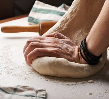 Persona amasando masa con un rodillo atrás